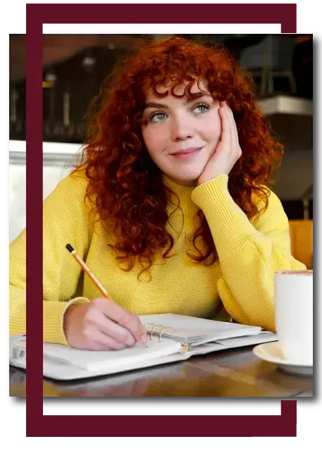 A female Australian student writing notes while studying for academic assignments